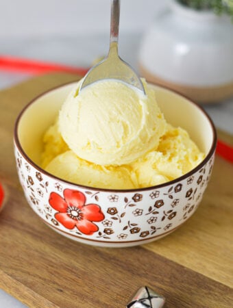 A bowl of Ninja Creami Eggnog Ice Cream, with a spoon sticking out of the festive dessert.
