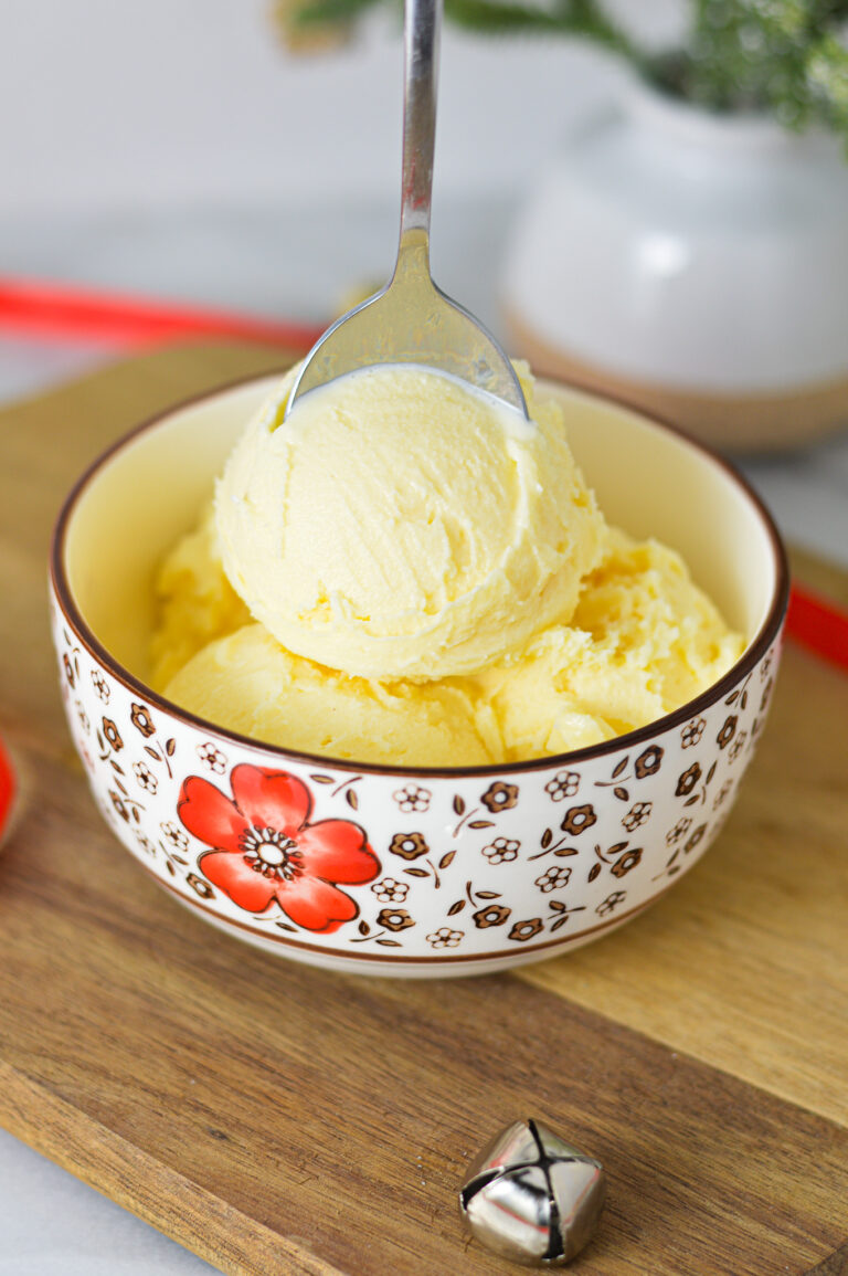 A bowl of Ninja Creami Eggnog Ice Cream, with a spoon sticking out of the festive dessert.