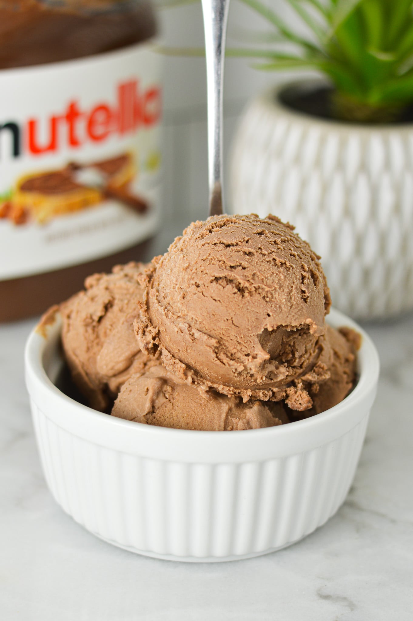 A small spoon in a small bowl full of Ninja Creami Nutella Ice Cream