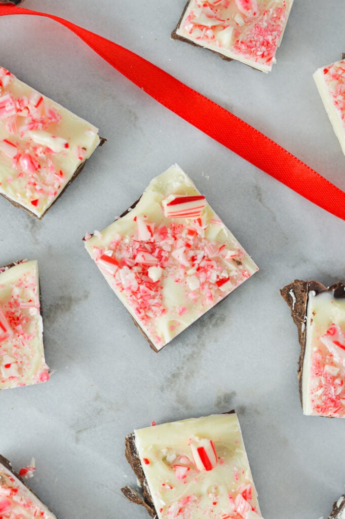 Some slices of Christmas Peppermint Bark, with the white chocolate layer covered in crushed peppermint candies.