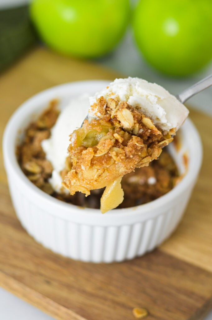 A spoon with a scoop of Apple Crisp for One, showing the oat and apple filling.