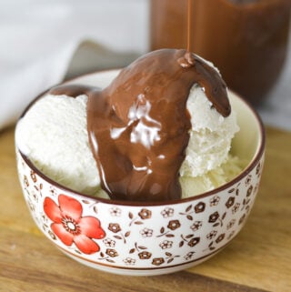 A bowl of ice cream with some Nutella Magic Shell being drizzled on top.