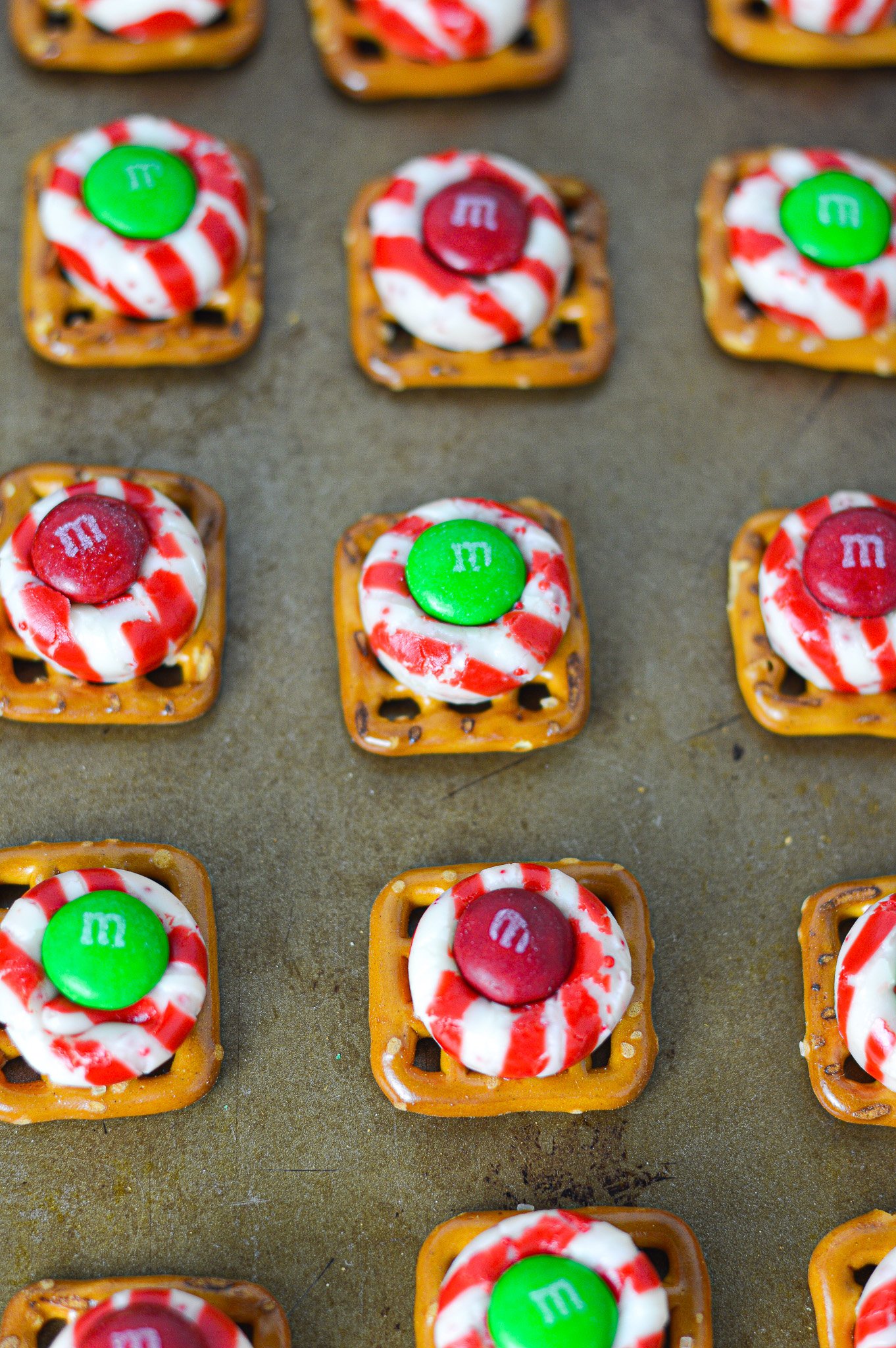 Some freshly baked Peppermint Kiss Pretzels on top of a baking sheet.
