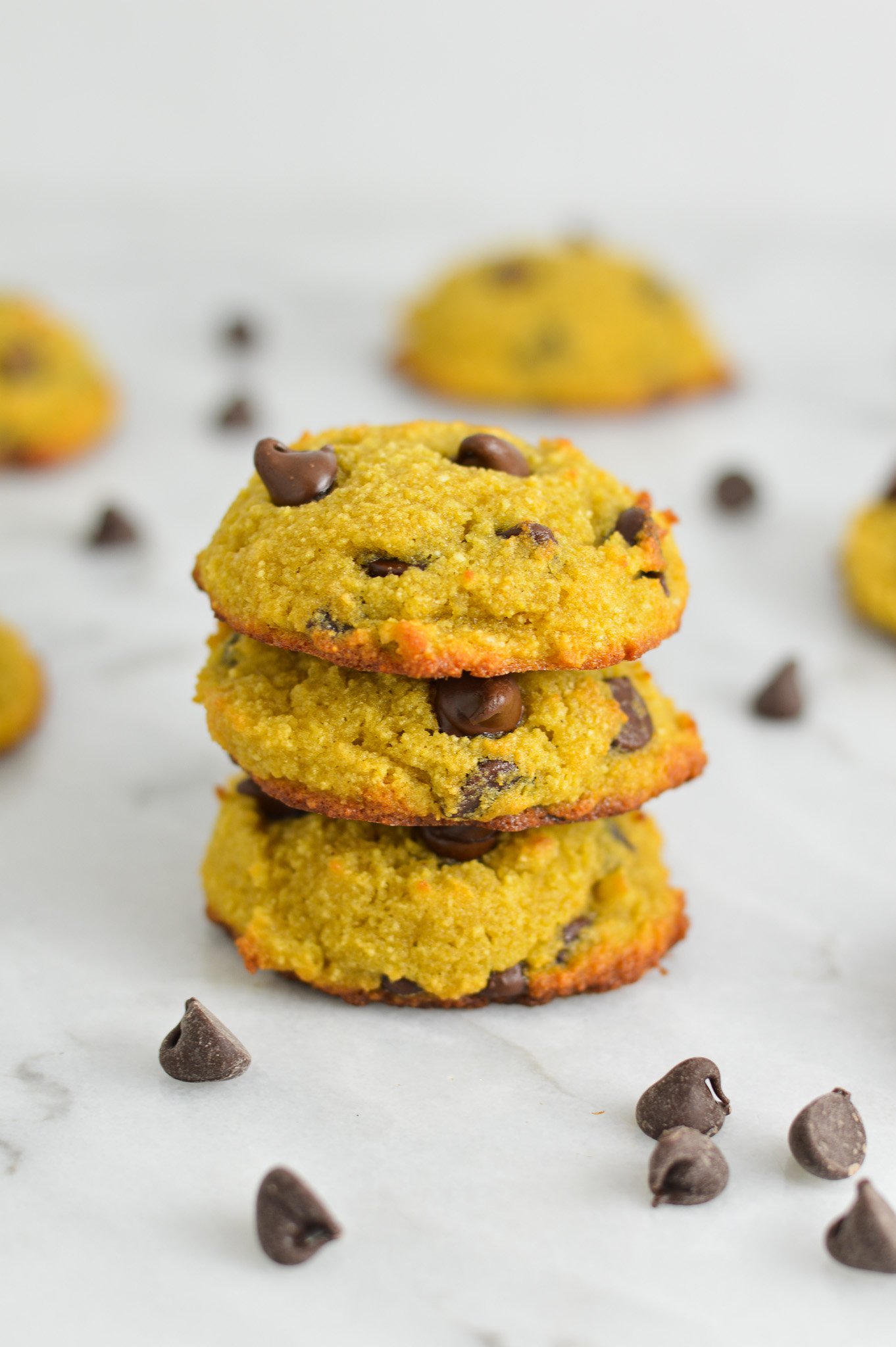 A stack of Coconut Flour Chocolate Chip Cookies, with the melty chocolate chips showing at the top of the soft cookies.