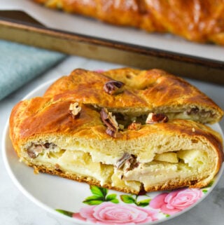 Two slices of Easy Apple Pecan Cream Cheese Pastry Braid, with the cream cheese and apple filling showing.