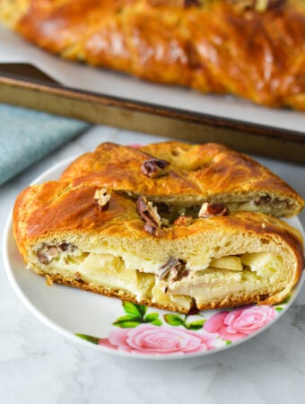 Two slices of Easy Apple Pecan Cream Cheese Pastry Braid, with the cream cheese and apple filling showing.