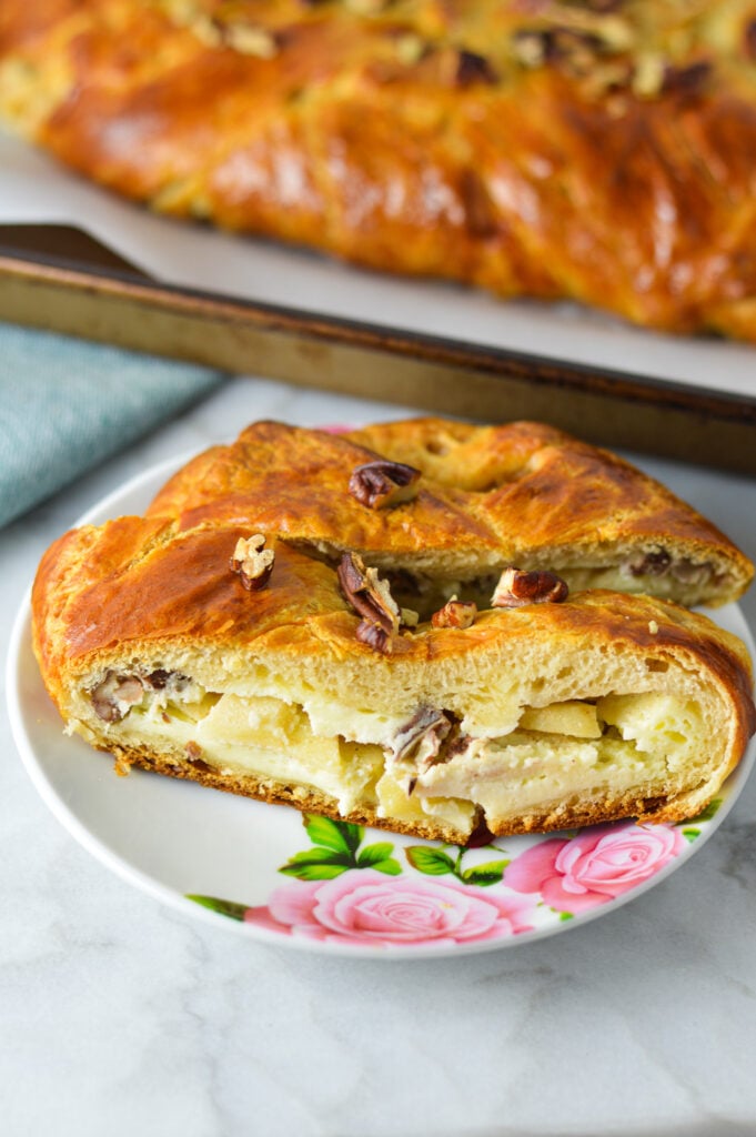 Two slices of Easy Apple Pecan Cream Cheese Pastry Braid, with the cream cheese and apple filling showing.