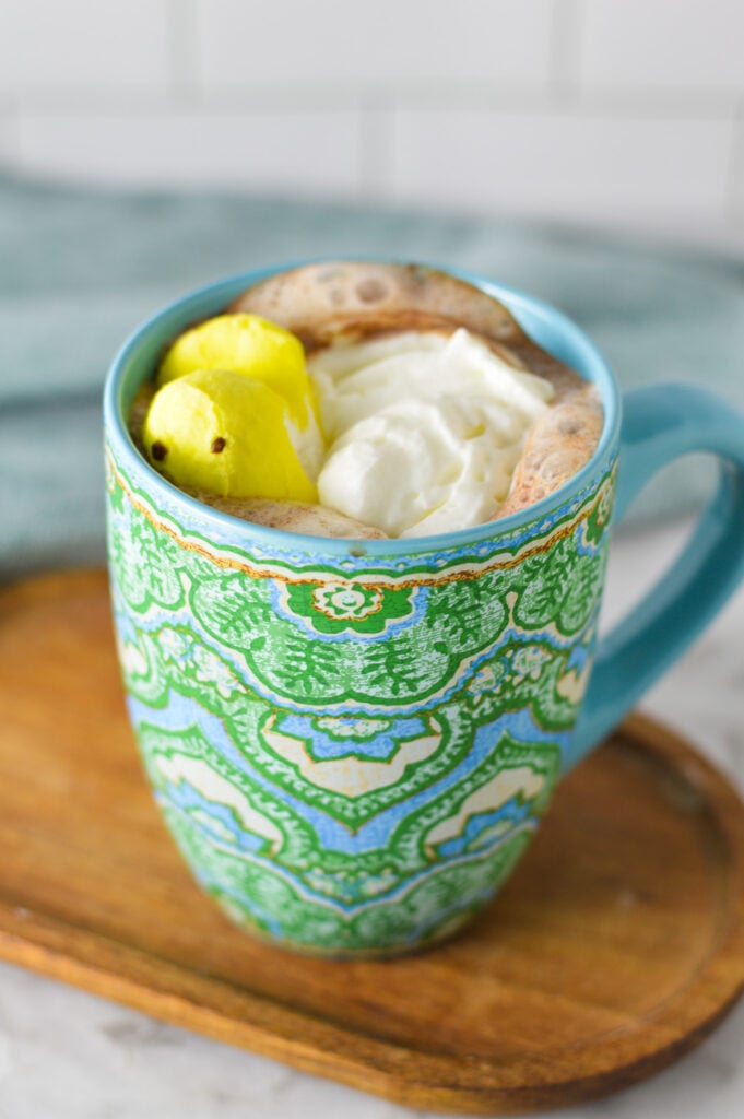 A large mug filled with Peeps Hot Chocolate, topped with whipped cream and a marshmallow peep.