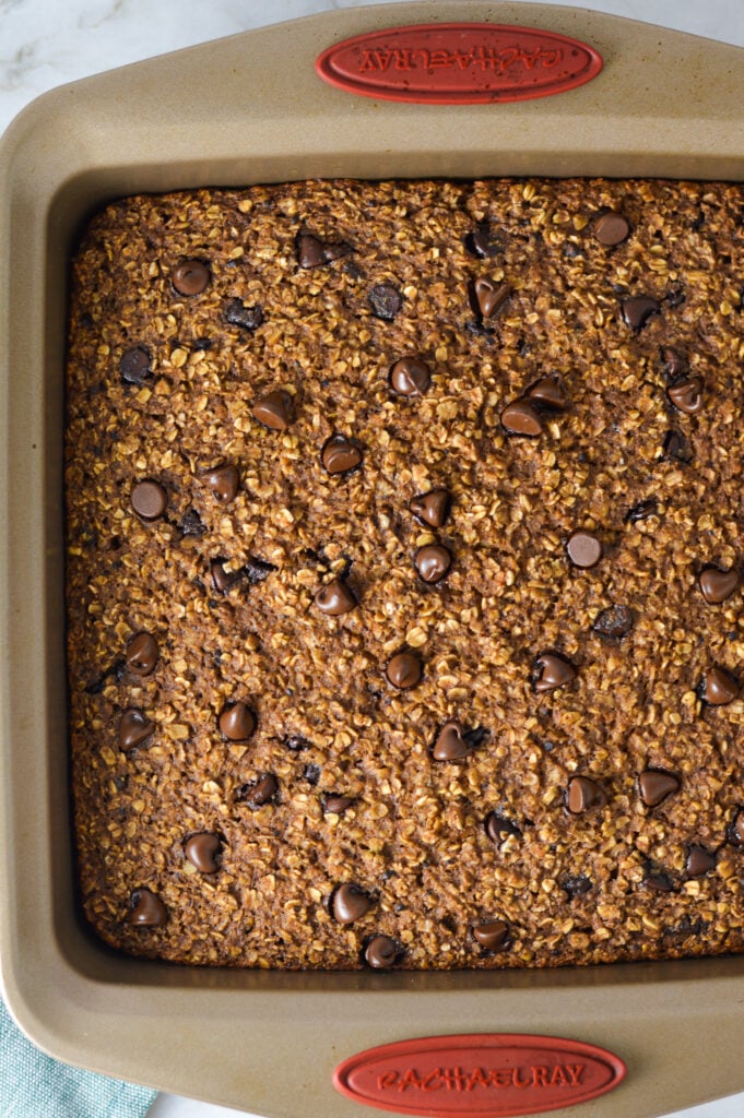 A square baking pan filled with Double Chocolate Baked Oatmeal, topped with semisweet chocolate chips.