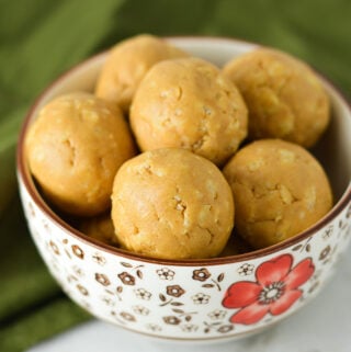 A small bowl filled with Rice Krispies Peanut Butter Balls, with the crispy rice cereal visible on the surface of the no bake peanut butter balls.