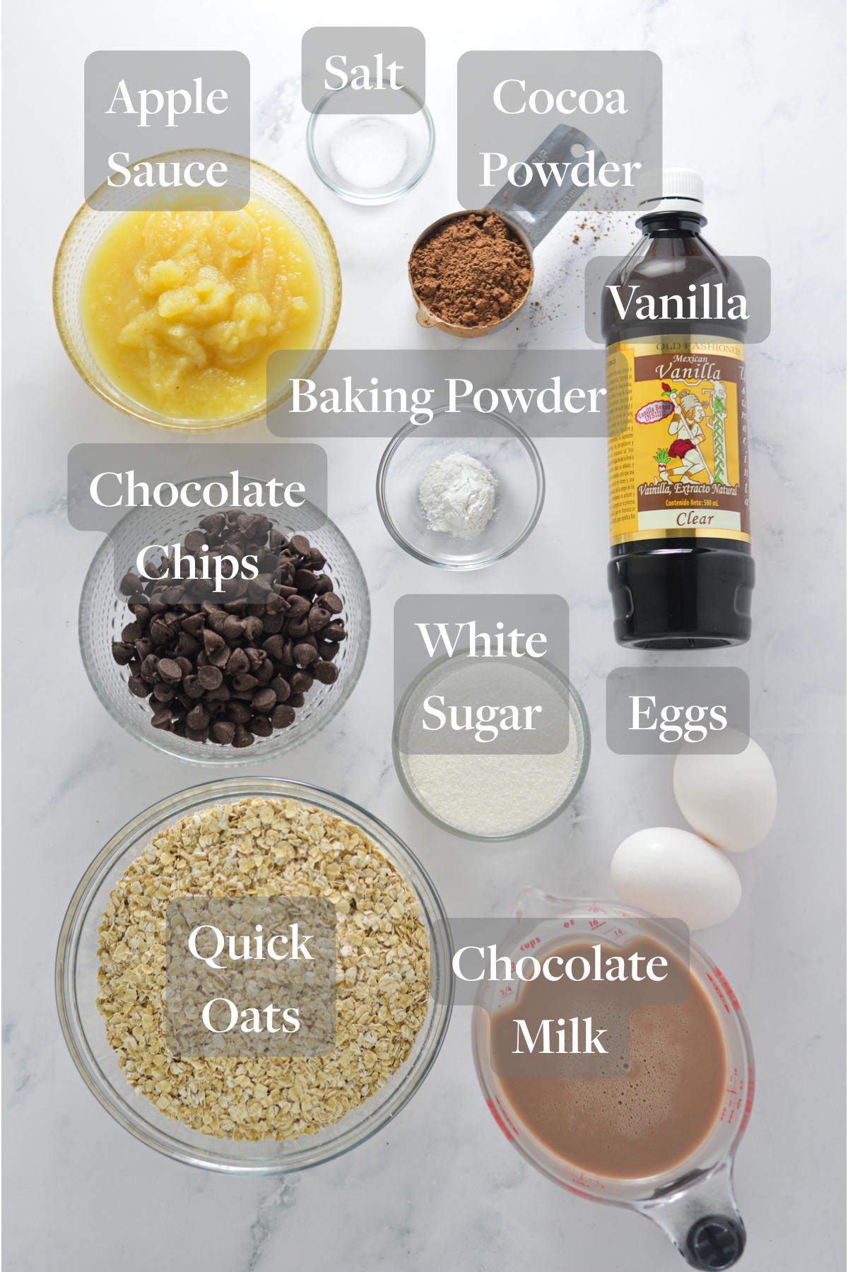 All of the ingredients needed to make Double Chocolate Baked Oatmeal laid out on a marble surface.