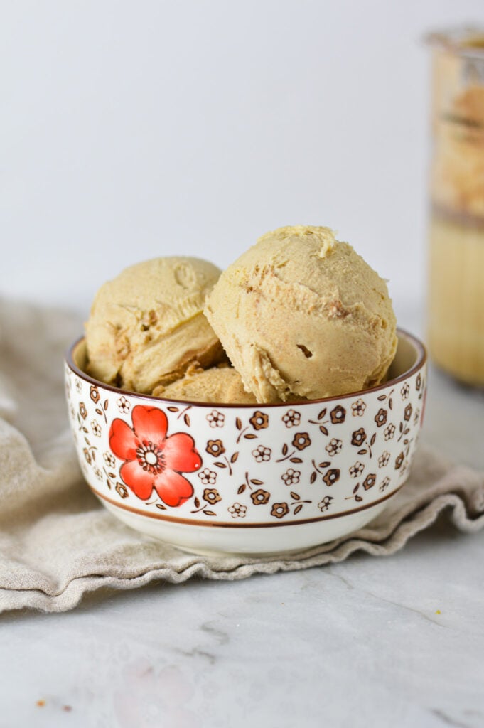 A bowl full of creamy Ninja Creami Cinnamon Protein Ice Cream, with the scoops showing its smooth texture.