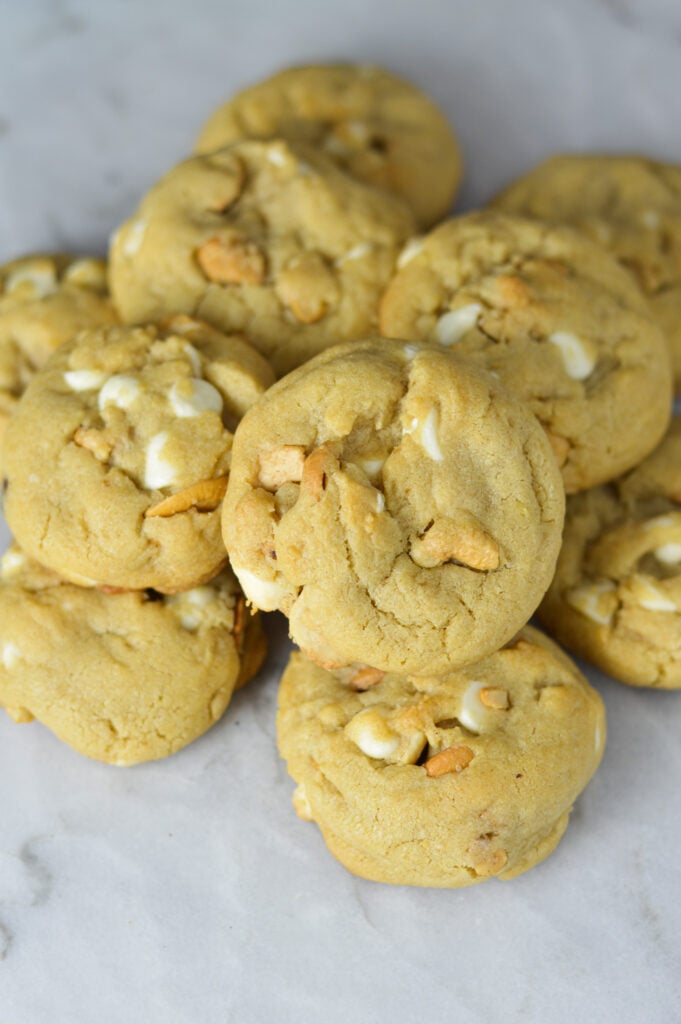 A pile of homemade White Chocolate Cashew Cookies, with the whole cashews and white chocolate chips showing on the tops of the cookies.