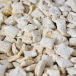 A parchment paper lined baking sheet filled with White Chocolate Puppy Chow.