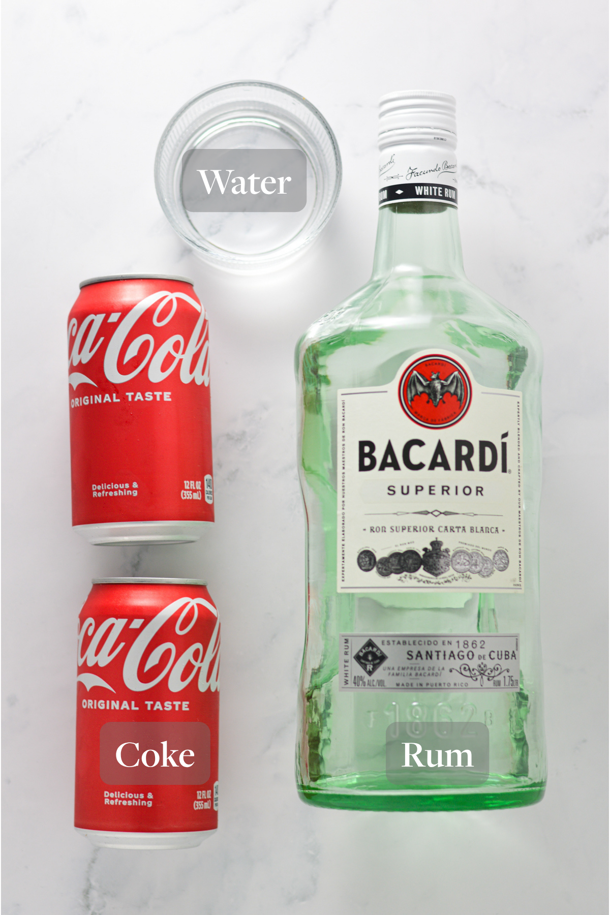 All the ingredients you need to make Ninja Slushi Rum and Coke laid out on a granite surface.