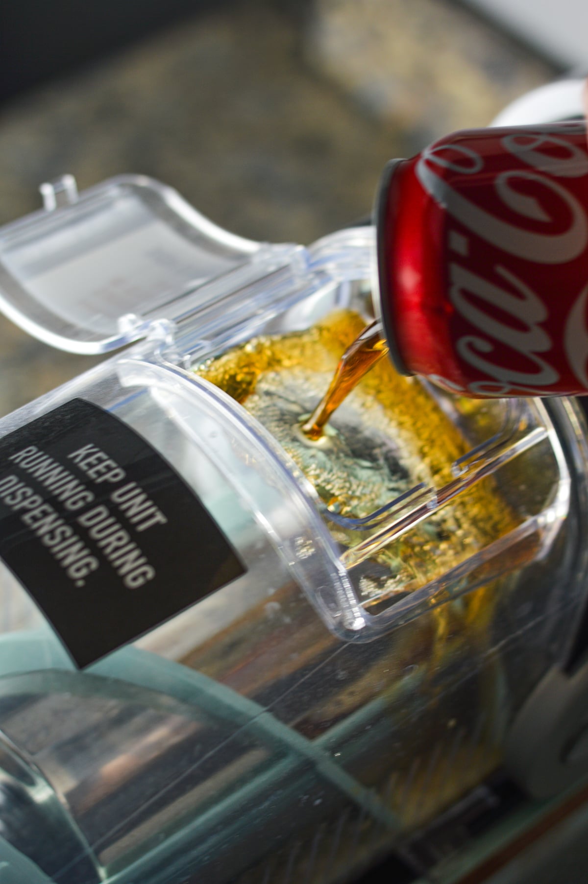 Coca Cola being poured into the vessel of the Ninja Slushi machine.