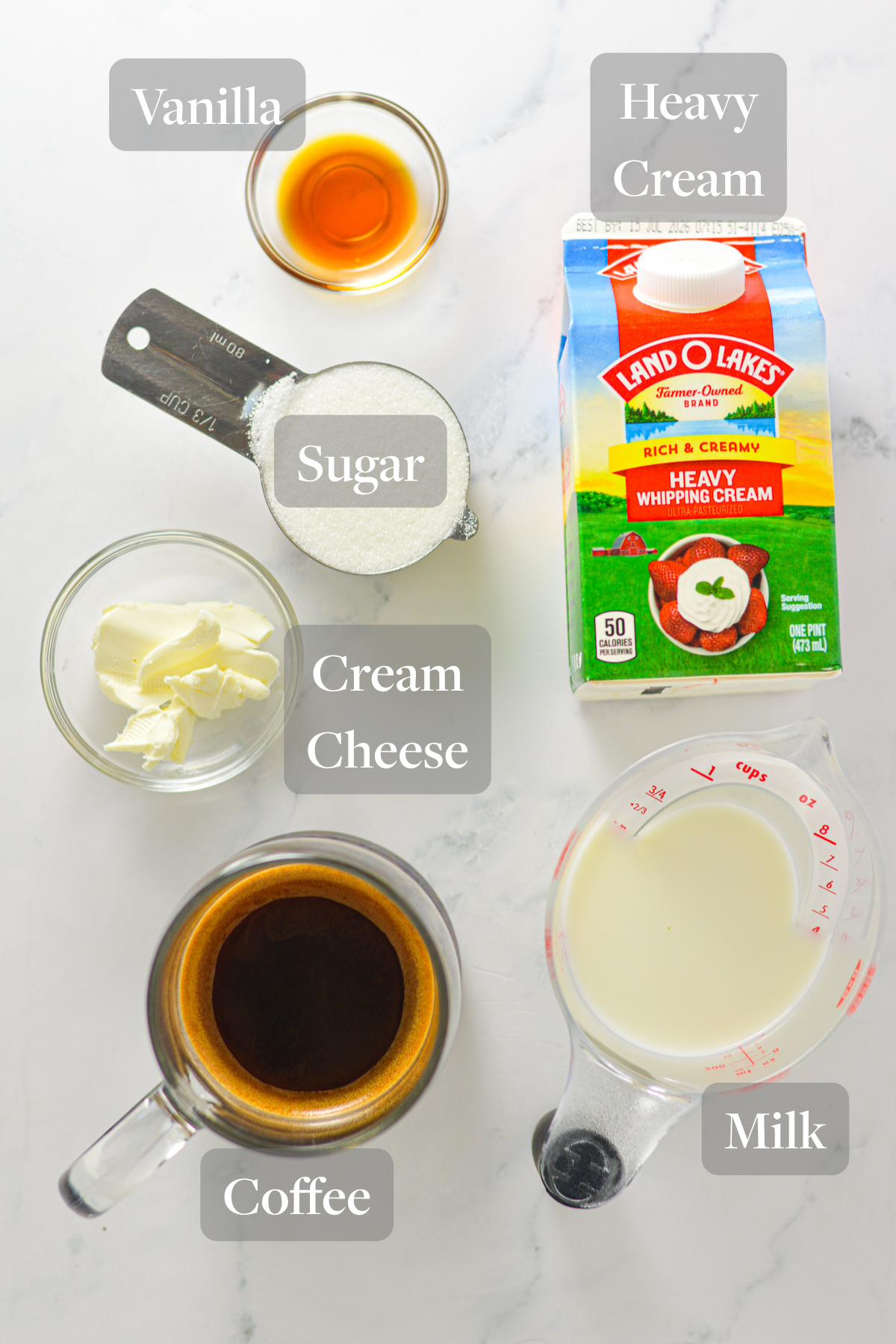 All the ingredients you need to make Ninja Creami Coffee Ice Cream laid out on a marble surface.